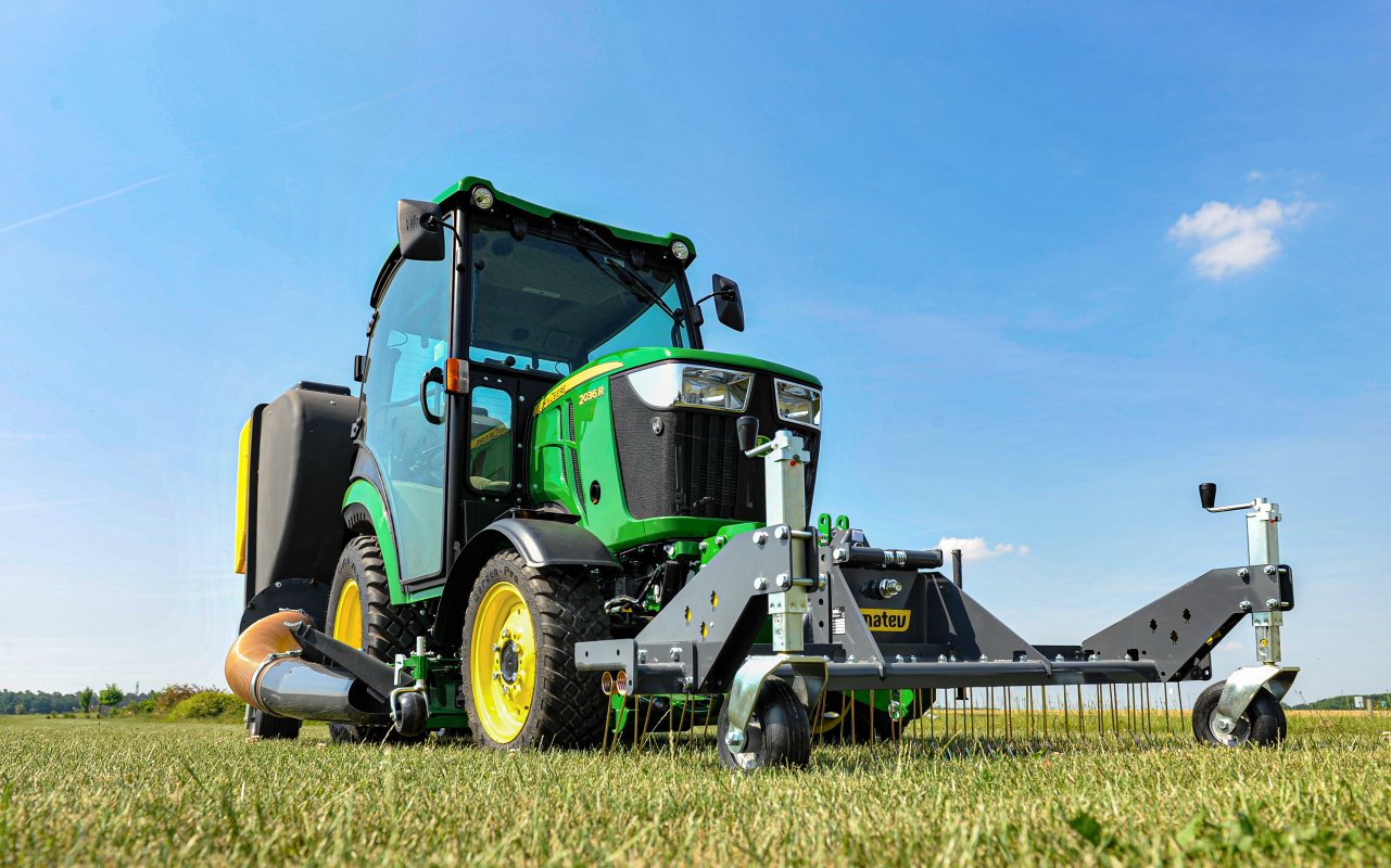 matev Rasenstriegel Anbaugerät für die Kommunaltechnik am John Deere 2036r auf einer Grünfläche.