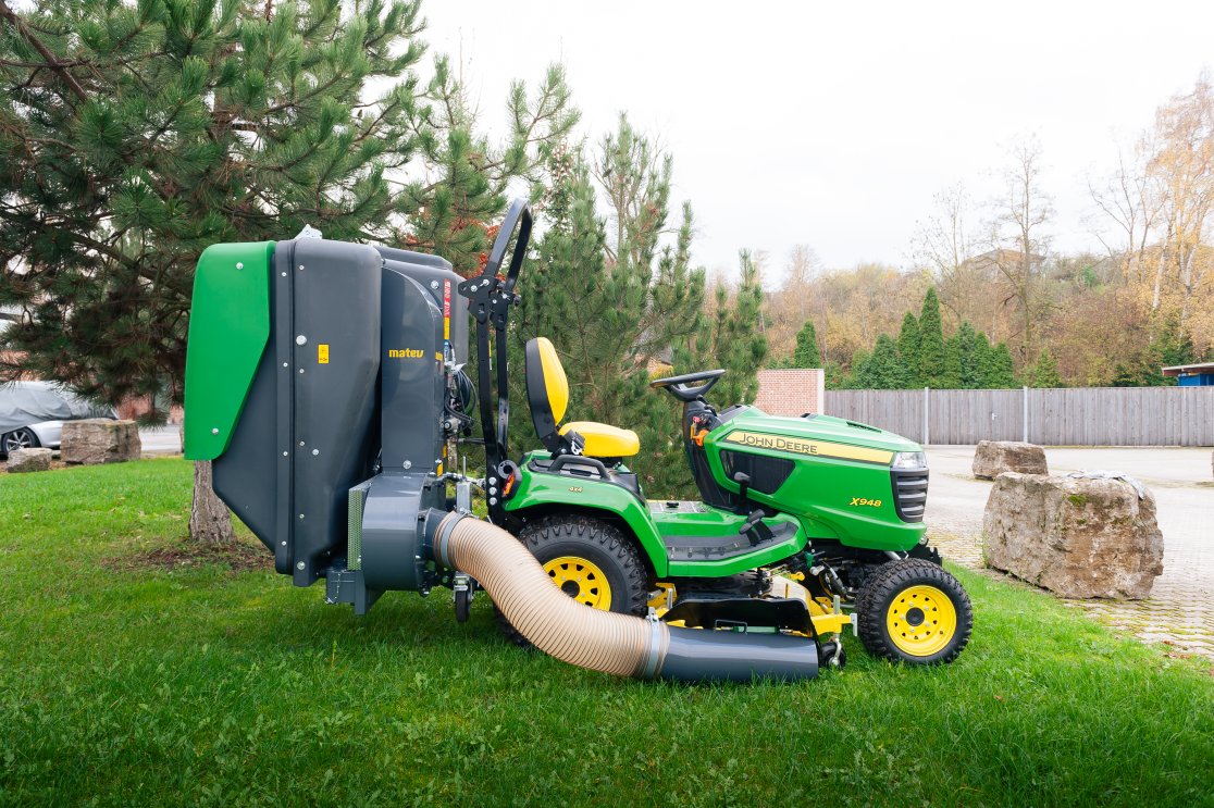 John Deere X948 mit dem Materialaufnahmegerät von matev für Traktoren in der Kommunaltechnik.